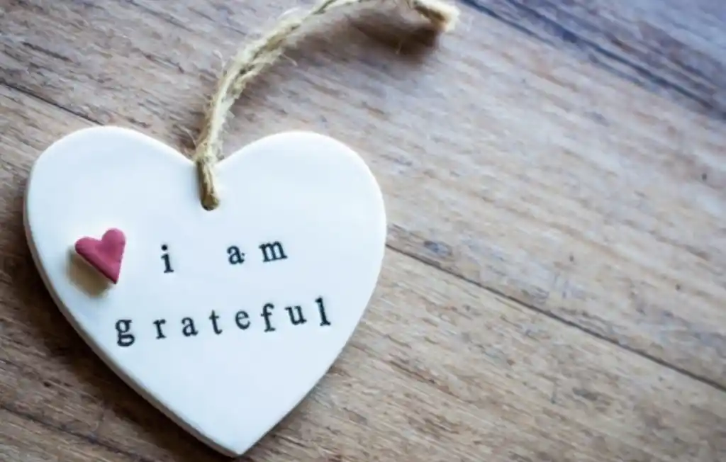 white heart on a string with text saying I am grateful